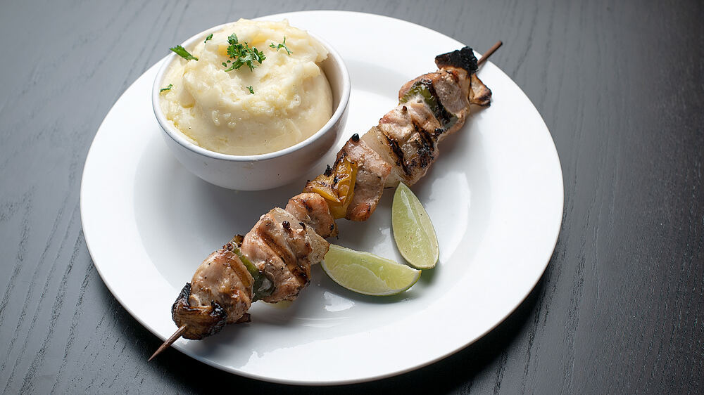 Brochette de pollo a la parrilla con puré y limón